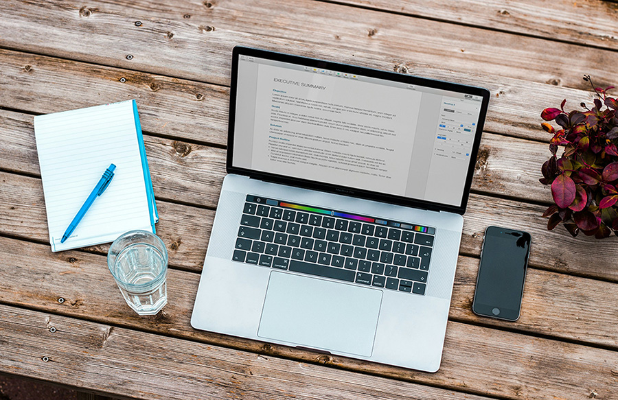 it-dienstleistungen-privatkunden-macbook MacBook auf Holzplatte – Symbol für IT-Dienstleistungen für Privatkunden